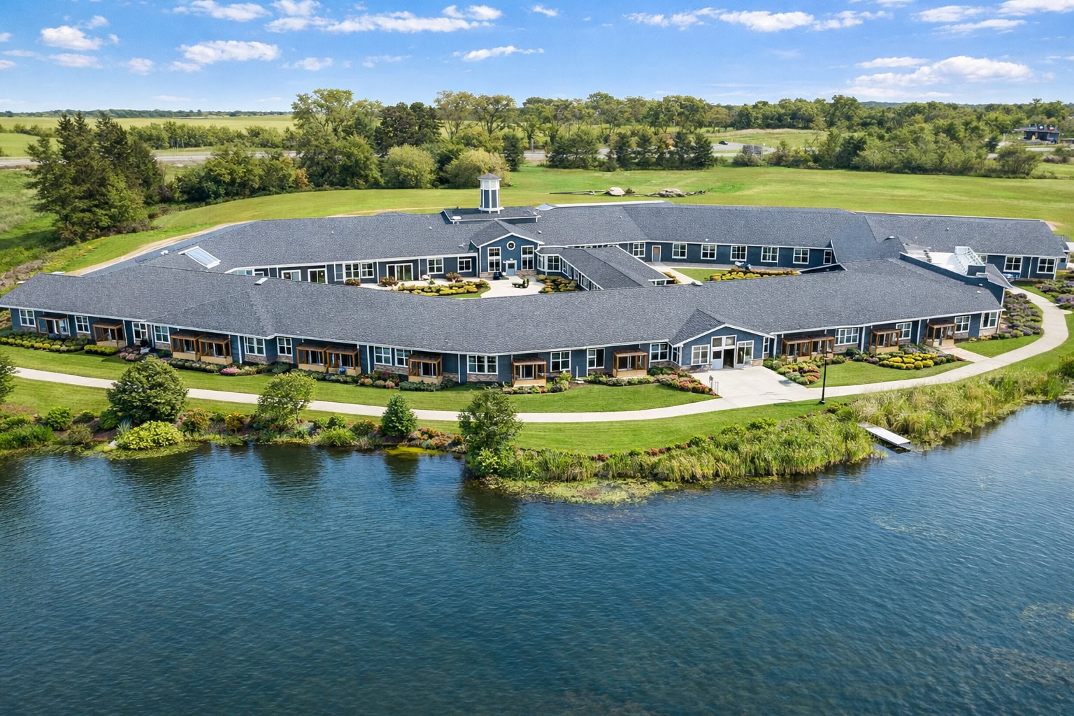 Aerial view of Bella Largo Senior Living surrounded by water and lush greenery.