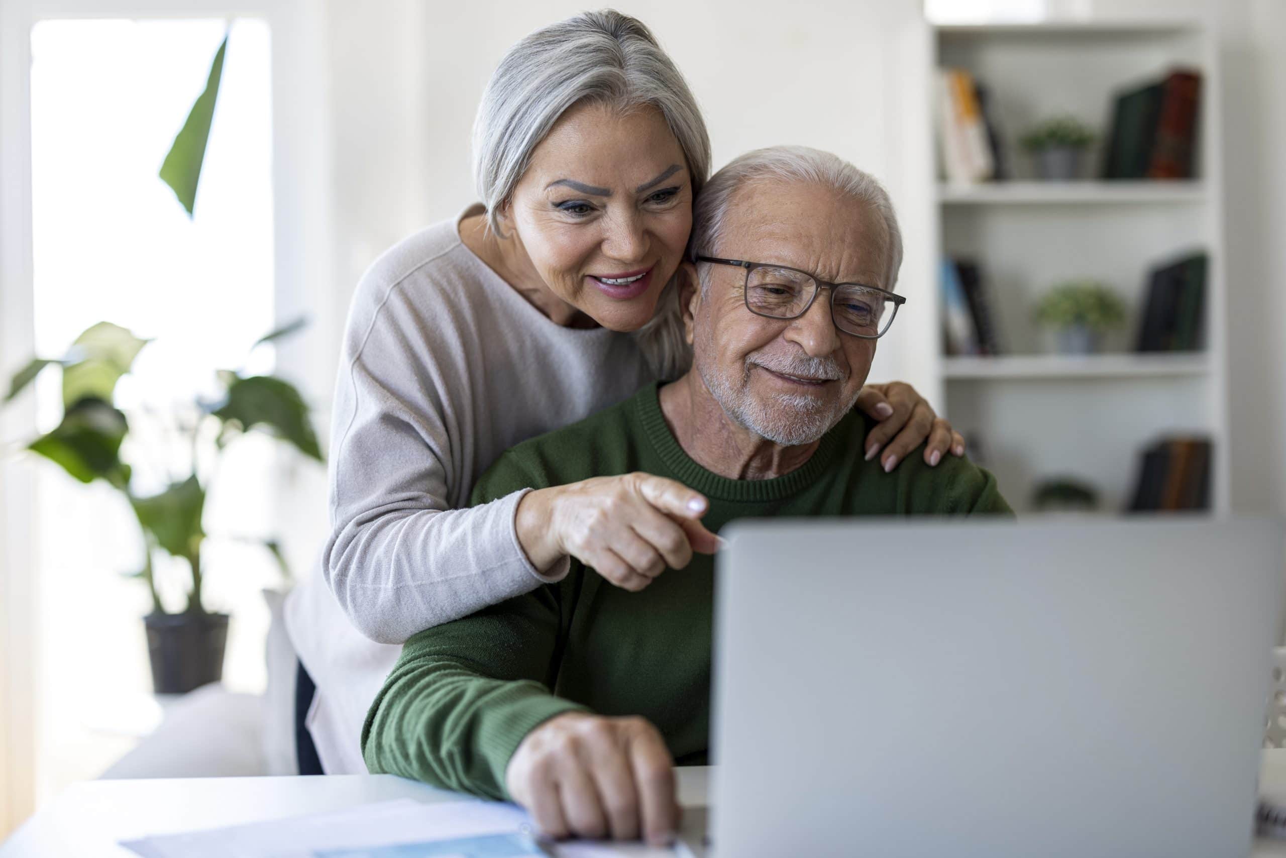 Senior couple exploring assisted living options online.