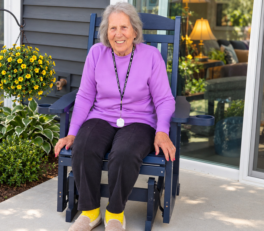 Senior woman sitting on porch chair with flowers and garden.
