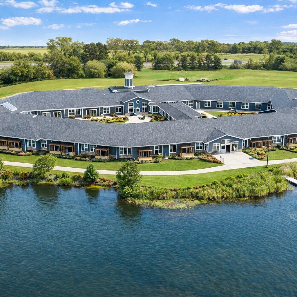 Aerial view of Bella Largo Senior Living surrounded by water and lush greenery.