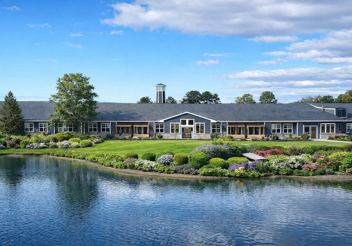 Beautiful exterior view of Bella Largo Senior Living community with lush landscaping and water featu.