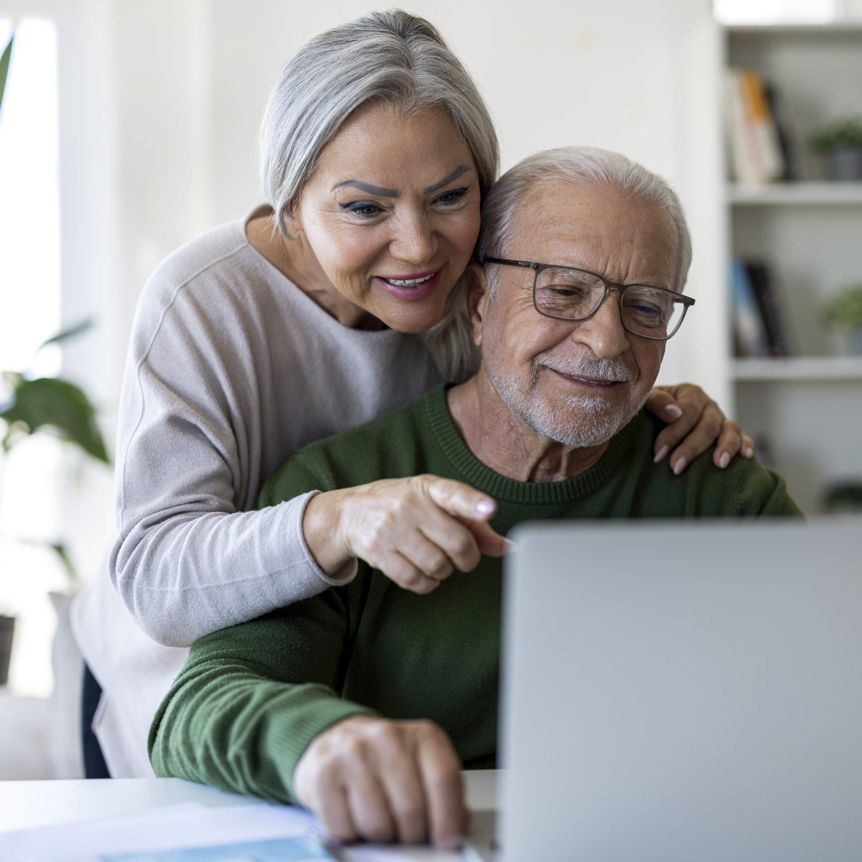 Senior couple exploring assisted living options online.