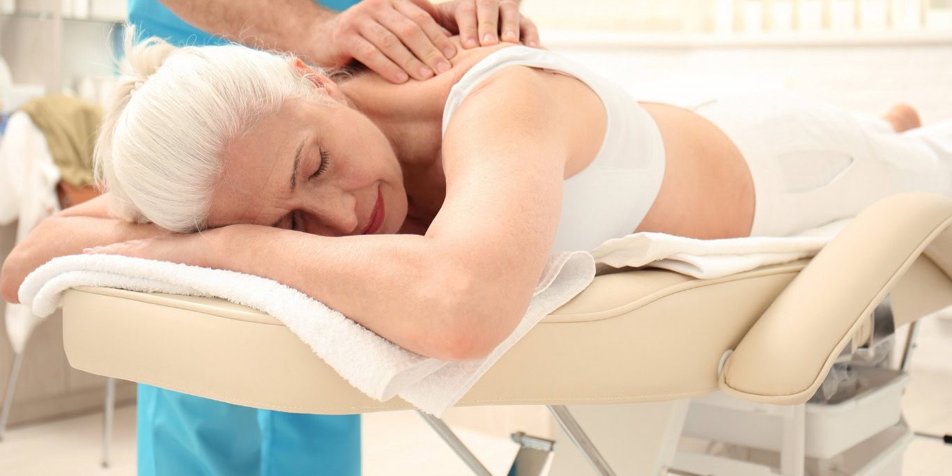 Elderly woman enjoying a massage therapy session at Bella Largo Senior Living community.
