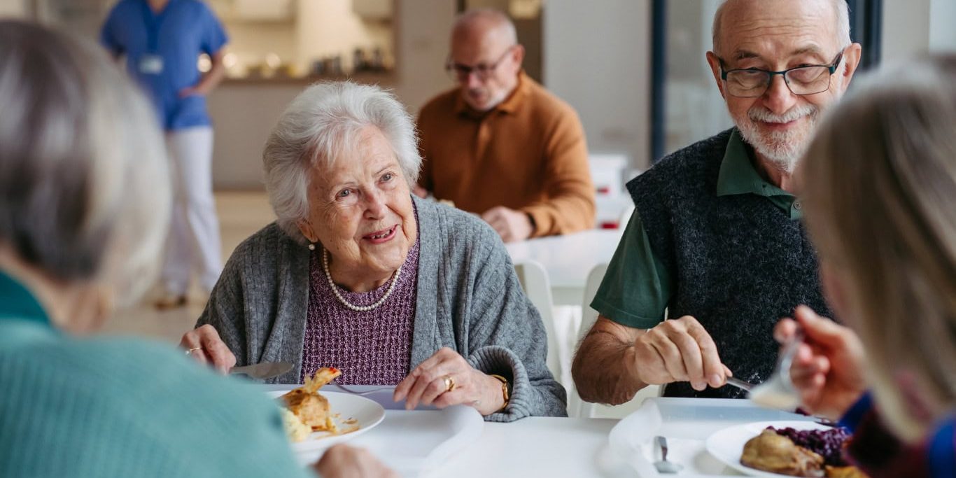 Senior residents enjoying a meal together at Bella Largo Senior Living community.